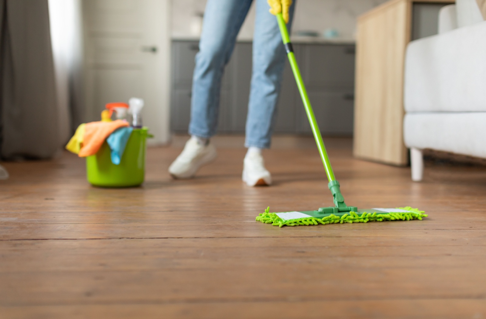 A woman mopping hardwood floors.