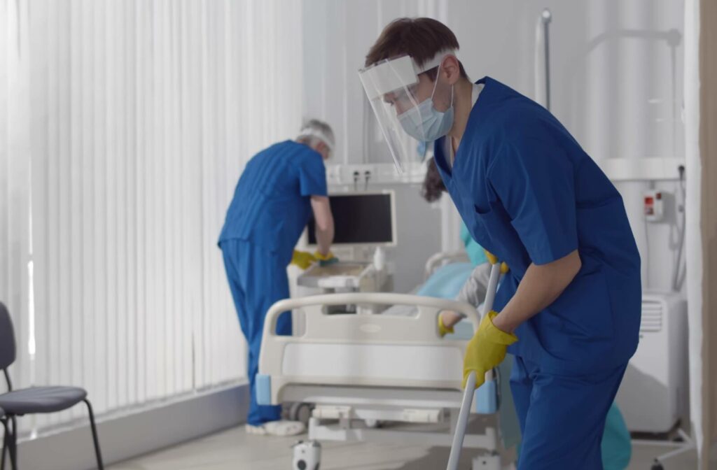 A professional cleaning team carefully sanitizes a medical room.