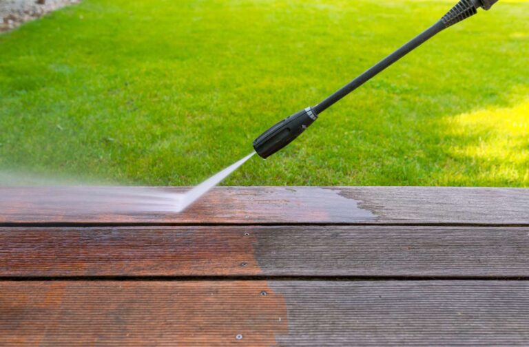 An old wooden deck being power washed.