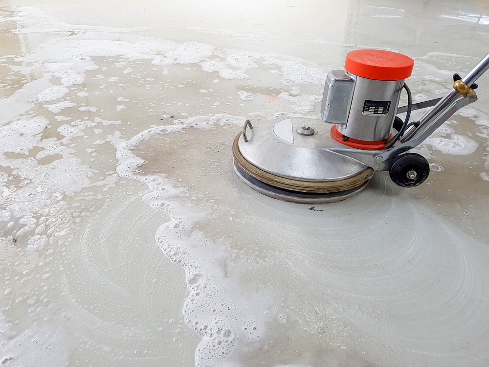 Polished concrete being cleaned with a floor scrubber.