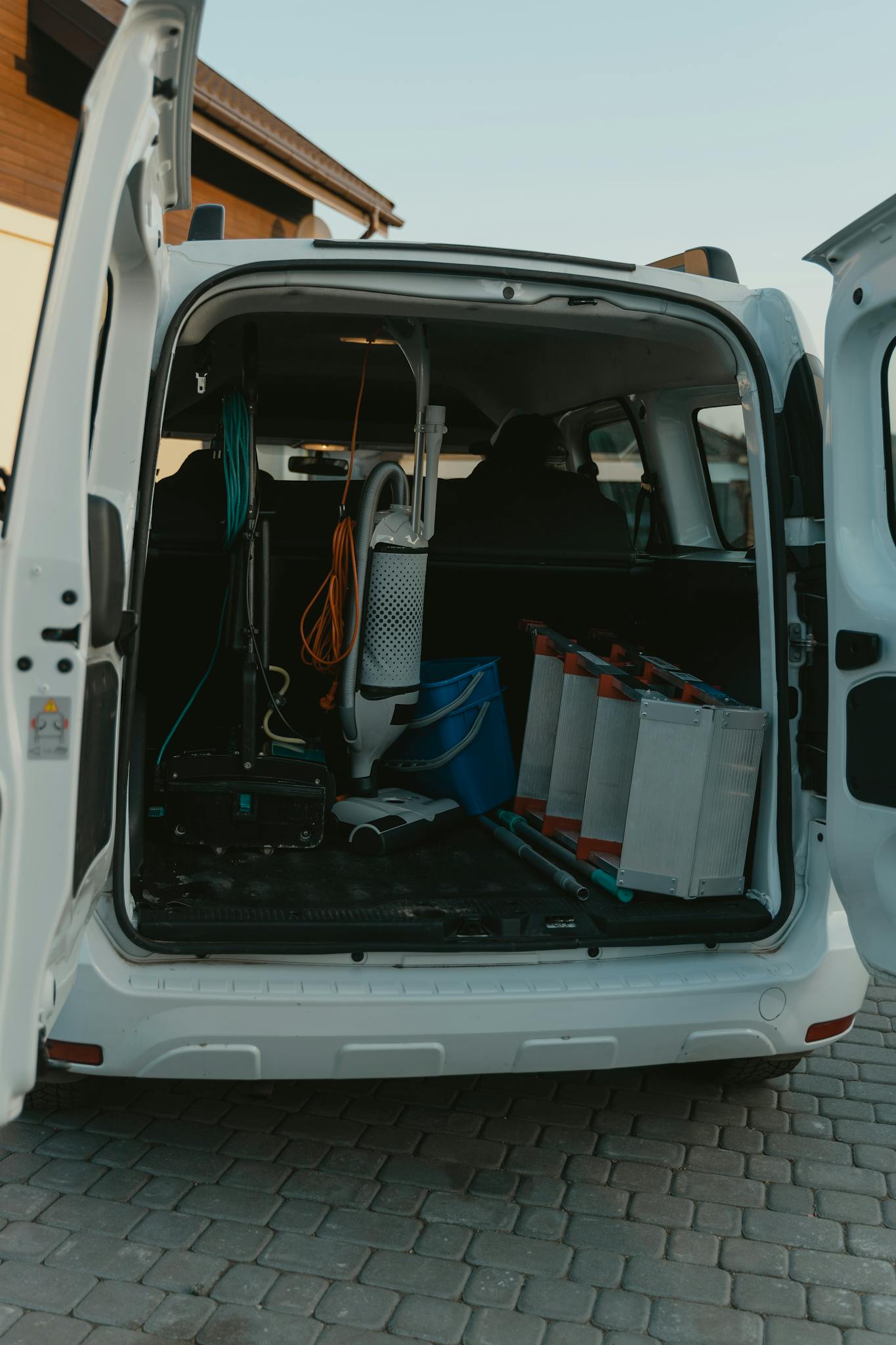 Rear view of open van showcasing cleaning equipment, ready for service.